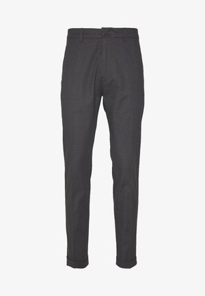 Uhlíkově šedé kalhoty s texturovaným vzorem, slim fit designem, zúženými nohavicemi a ohrnutými lemy. Obsahují poutka na opasek a přední zip.