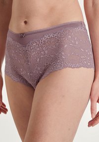 Lavendelblonde truse med blomstermønster, elastisk midje og bølgete kanter. Myk, semi-transparent tekstur.
