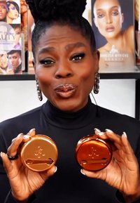 Kaksi pyöreää, kiiltävää kupariastiaa pidetään käsissä, joissa on ylhäällä rako. Suunniteltu kauneustuotteille, joissa on sileät, heijastavat pinnat.