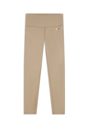 Leggings beige de cintura alta para mujer con costuras visibles y pequeño logo reflectante en la cadera derecha, mostrados planos sobre un fondo blanco.