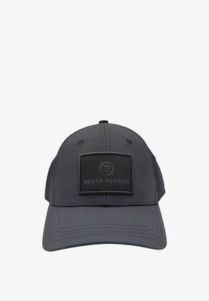 Casquette de baseball noire avec une pièce rectangulaire affichant un logo circulaire et le texte "SERGE BLANCO" au centre de l'avant.