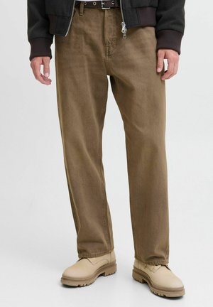 Brown cotton pants with a straight cut, featuring tonal hardware and a smooth texture, paired with beige footwear.