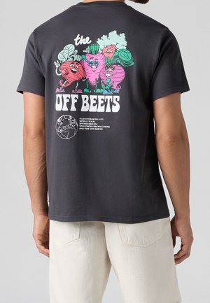 Czarna koszulka z kolorowymi, kreskówkowymi burakami w okularach i trampkach, tekst "the OFF BEETS" oraz grafiką globu na plecach.