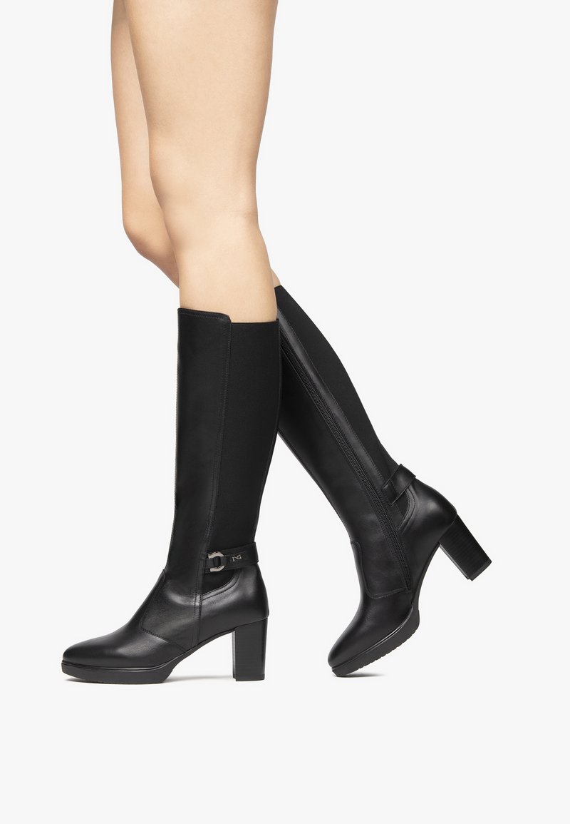 Black knee-high boots featuring a combination of smooth leather and elastic material, with a block heel and decorative buckle detail.