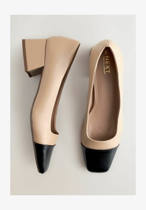 Beež nahast kontsaking, millel on ruudukujuline ninaosa, musta nahast ninaosa ja plokkkonts. Sile tekstuur ja minimaalne disain.