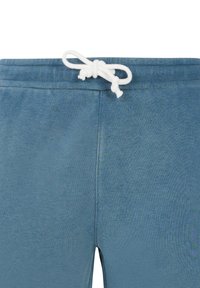 Pantalon de survêtement en coton bleu avec une taille à cordon de serrage, présentant une texture lisse et un design minimaliste, sans poches visibles.