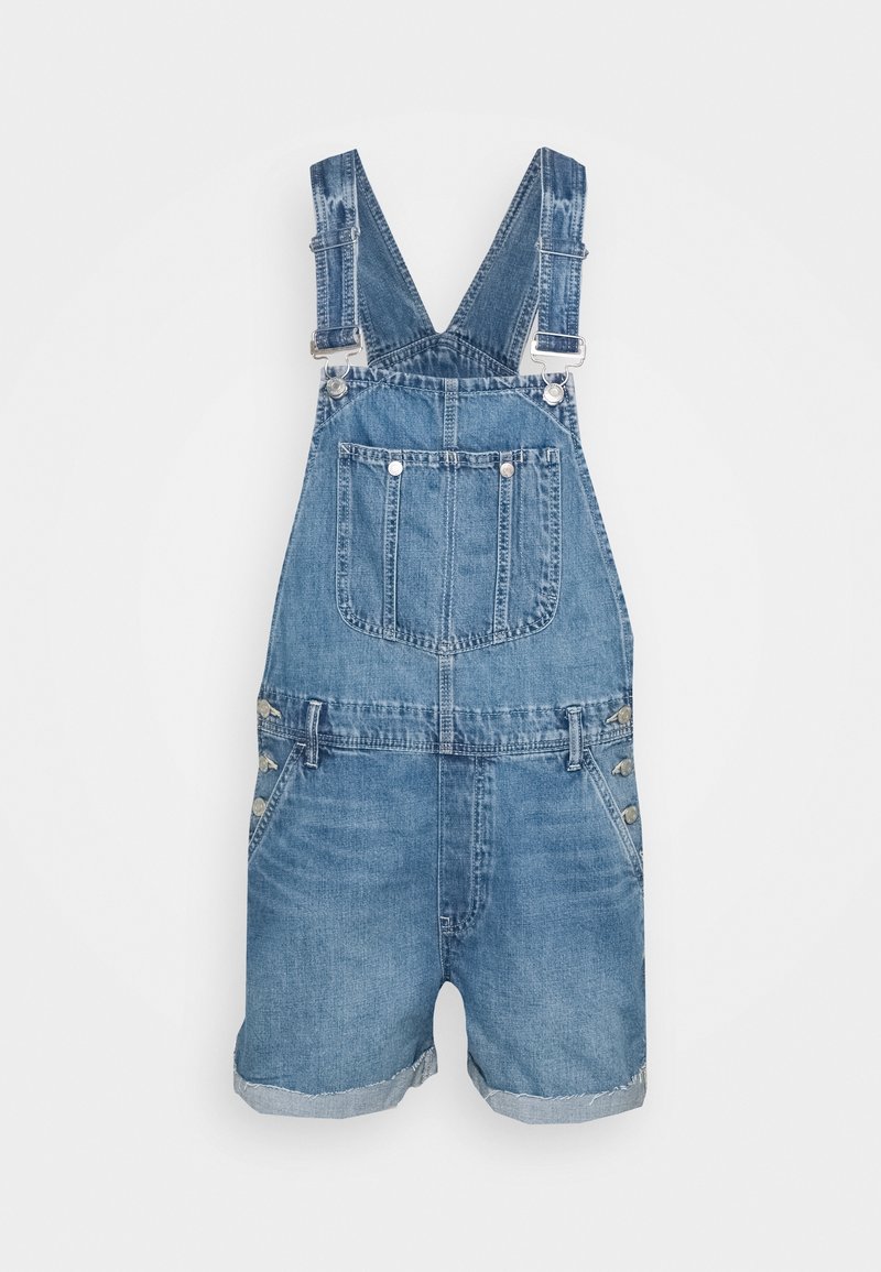 Salopette courte en denim bleu avec poche avant, bretelles réglables et détails de boutons sur les côtés, présentée sur fond blanc.