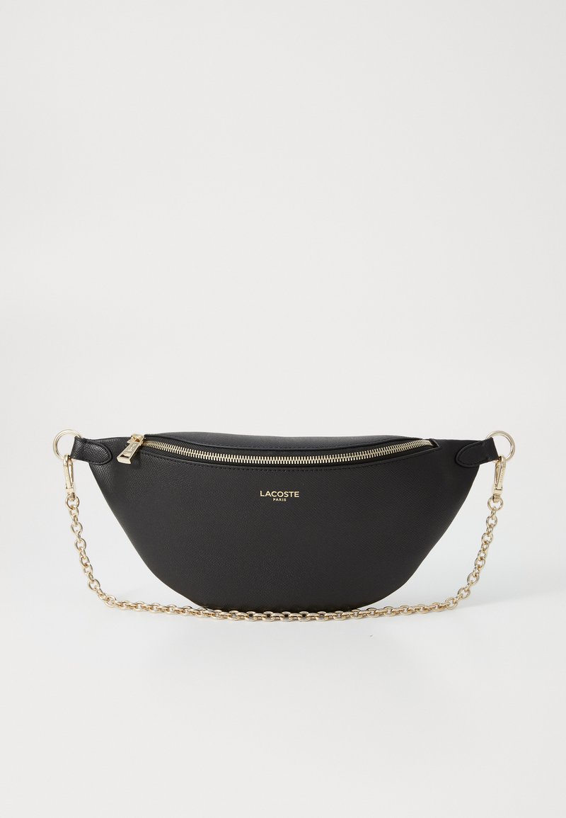 Borsa a tracolla in pelle sintetica nera con forma curvata, tracolla in catena color oro e chiusura con zip. Presenta il logo Lacoste sul fronte.
