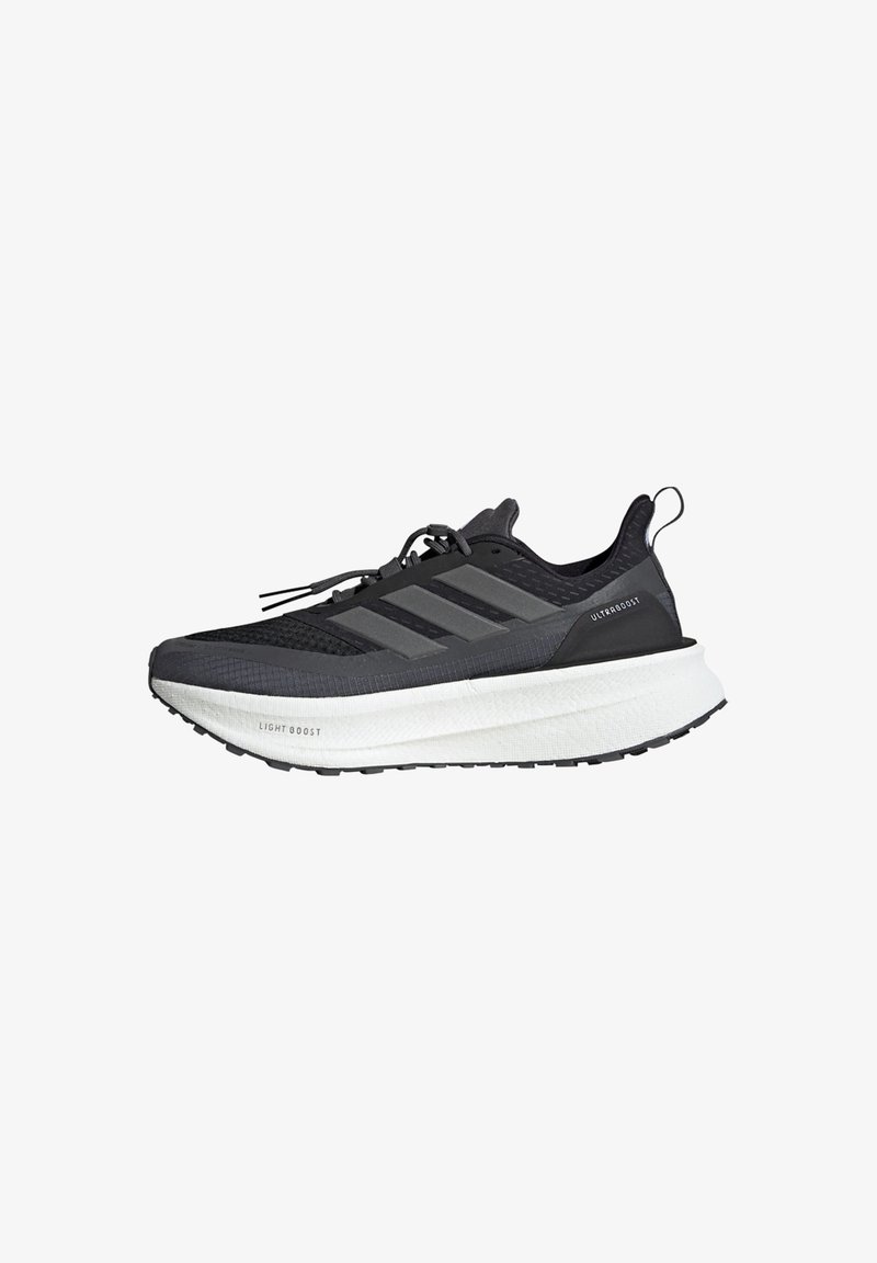 Black athletic shoe with a mesh upper, three grey stripes, a thick white sole, and textured detailing. Features a pull tab at the heel.