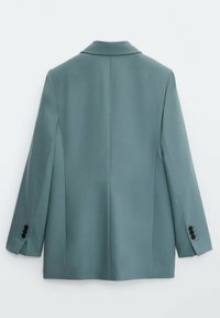 Blazer bleu clair sur mesure avec manches longues et boutons noirs aux poignets, vu de dos sur fond blanc.