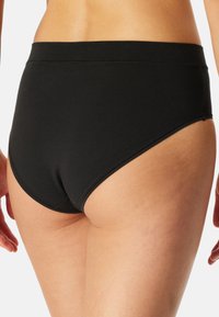 Schwarzer, hochgeschnittener Baumwollslip mit nahtlosem Design. Weiche Textur mit breitem Bund und ohne sichtbare Nähte für eine glatte Passform.