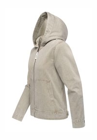 Giacca in cotone beige con cappuccio, chiusura frontale a zip e due tasche grandi. Presenta una finitura tessurizzata e una vestibilità rilassata.