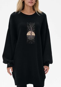 Czarna, oversize bluza z nadrukiem drzewa i ilustracją słońca na środku. Posiada długie rękawy i ściągacze. Miękka w dotyku.