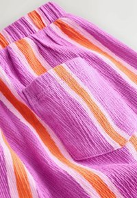 Shorts en tissu texturé rayés rose, orange et blanc, dotés d'une ceinture élastique et d'une petite poche arrière.