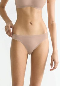 Nude-farbene Baumwoll-Bikini-Unterwäsche mit glatter Textur, mittlerer Bedeckung und einem weichen, elastischen Bund. Minimale Nähte.