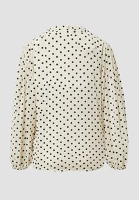 Cremfarbene Bluse mit langen Ärmeln, schwarzen Punkten, gerafften Manschetten und Rundhalsausschnitt, von hinten auf einem einfarbigen Hintergrund gezeigt.