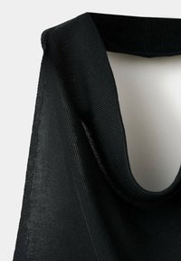 Haut sans manches en maille noire avec un large décolleté arrondi suspendu sur un fond clair.