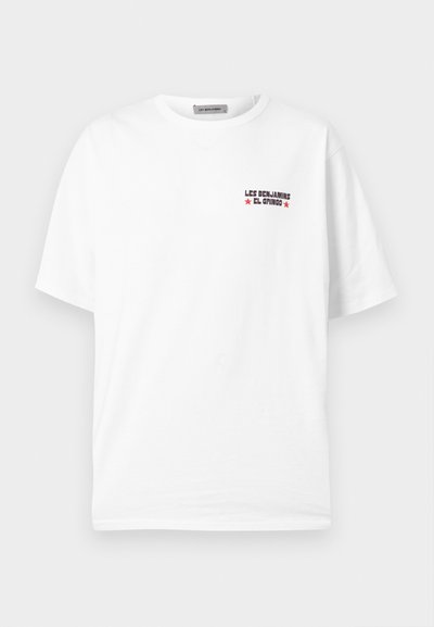 Λευκό κοντομάνικο μπλουζάκι με μικρό κόκκινο και μαύρο κείμενο "LES BENJAMINS EL GRINGO" και δύο κόκκινα αστέρια στην αριστερή πλευρά του στήθους.