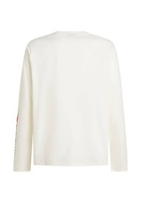 Long-sleeve shirt in white fabric, featuring a round neckline and printed text design in black and red on the left sleeve.