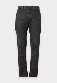 Jeans negros de corte ajustado con un acabado desgastado. Incluye bolsillos frontales, detalles de costura y paneles reforzados en las rodillas.