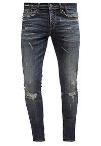 Jean slim bleu foncé avec détails usés et déchirures aux cuisses et aux genoux, avec poches avant et passants pour ceinture.