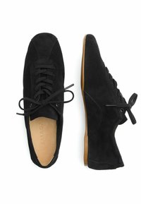 Scarpe in suede nere con punta arrotondata, design con lacci e suola in gomma color sabbia. Presentano una superficie liscia e uno stile minimalista.