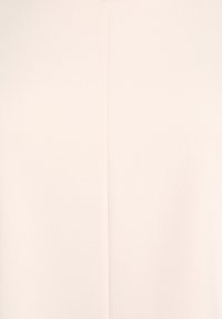 Jasno beżowa tkanina o gładkiej fakturze i subtelnym połysku, z centralnym szwem biegnącym pionowo wzdłuż długości.