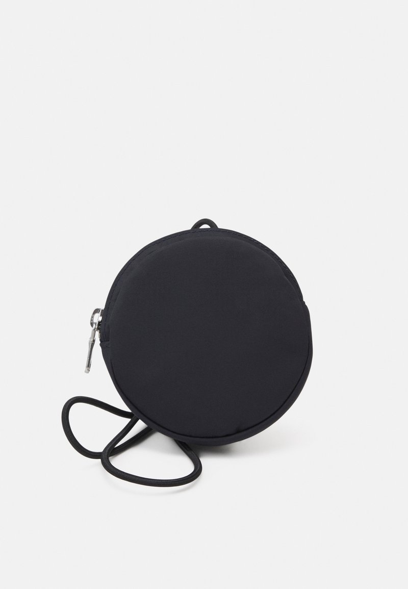 Sac bandoulière rond noir en tissu doux avec fermeture éclair et fine bandoulière. Texture lisse avec un design minimaliste.