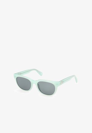 Lunettes de soleil rectangulaires vert clair avec des verres foncés et des branches légèrement courbées, présentées en angle sur un fond blanc.