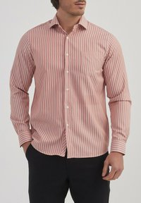 Chemise rayée en corail et blanc, à manches longues, col standard, poche avant, boutons sur le devant, fabriquée en tissu lisse.