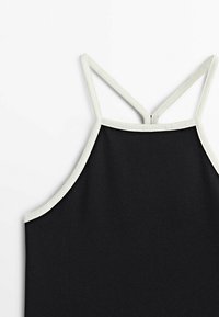 Top sans manches noir avec de fines bretelles blanches et un bord blanc le long de l'encolure et des emmanchures, présenté sur un fond blanc.