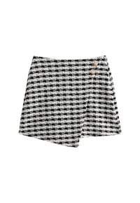 Zwart-wit geruit wikkelrok van textuurstof, met twee decoratieve knopen op de taille en een asymmetrische zoom.