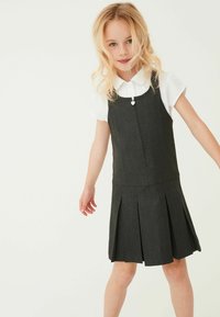 Robe en denim gris foncé avec une jupe plissée. Dotée d'encolure droite, de bretelles réglables et d'une petite tirette en forme de cœur. Chemise blanche à col en dessous.