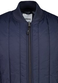 Mörkblå quiltad bomberjacka med ribbad krage, framtill dragkedjestängning och vertikala sömnadsdetaljer för textur och isolering.