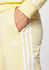 adidas Sportswear ESSENTIALS 3-STRIPES - Treniņtērps - almost yellow/white