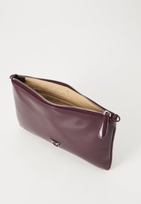 Bordo kožni clutch s patentnim zatvaračem, glatke teksture i svijetlosmešnatog interijera. Sadrži suptilan metalik akcent.