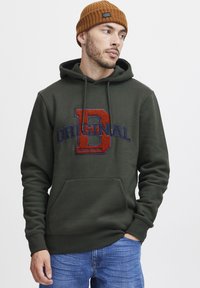 Green hoodie with a kangaroo pocket, featuring a large red and blue "D" embroidered logo and "ORIGINAL" text. Ribbed edges at the cuffs.
