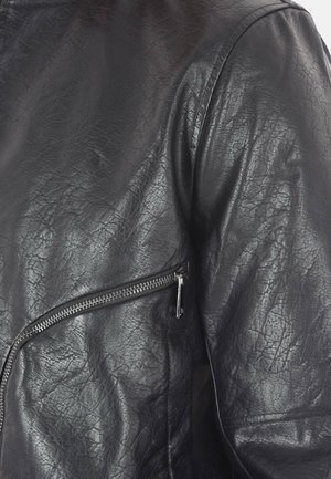 Giacca in pelle nera con superficie texturizzata, tasca con zip sul lato e un design elegante e aderente con dettagli di cucitura minimi.