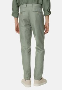 Lichtgroene broek met een slim fit, voorzien van twee achterzakken met knoopsluitingen en een gladde, textuurstof.
