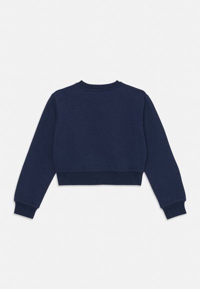 Tengerészkék, hosszú ujjú, rövidített pulóver bordázott mandzsettákkal és szegéllyel, hátulról világos, egyszínű háttéren bemutatva.