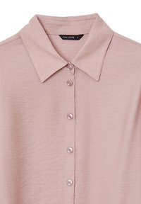 Camicia collare rosa chiaro realizzata in tessuto morbido, con sei bottoni coordinati e una texture sottile. L'etichetta riporta "CALLIOPE", taglia piccola.