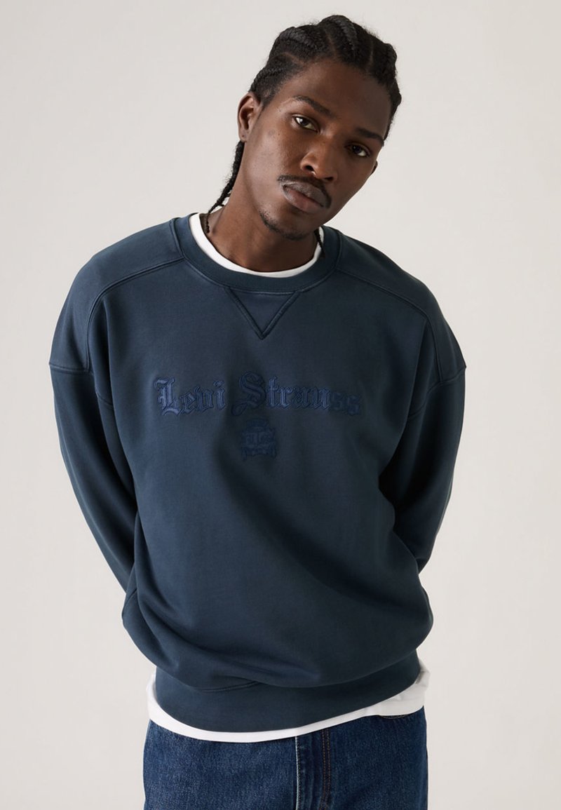 Μπλε ναυτικό φούτερ με στρογγυλή λαιμόκοψη και κεντημένο λογότυπο "Levi Strauss" σε πιο σκούρη απόχρωση. Διαθέτει ριμπ μανσέτες και τελείωμα.