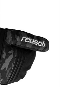 Schwarze Handschuhe mit Camouflage-Muster und strukturierter Oberfläche; verfügen über einen markierten Riemen mit "reusch" in weißer Stickerei.
