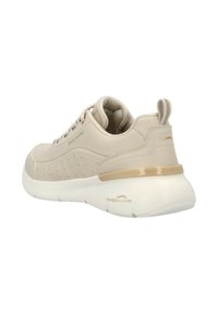 Zapatilla deportiva beige con parte superior sintética lisa, detalles laterales perforados, cuello acolchado y suela blanca acolchada con acentos dorados.