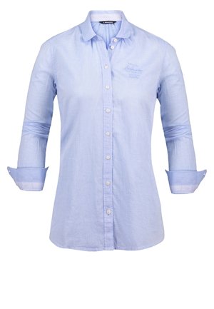 Chemise bleu clair à manches longues avec col, boutons blancs, poignets retournés, avec une broderie discrète sur le côté gauche de la poitrine.