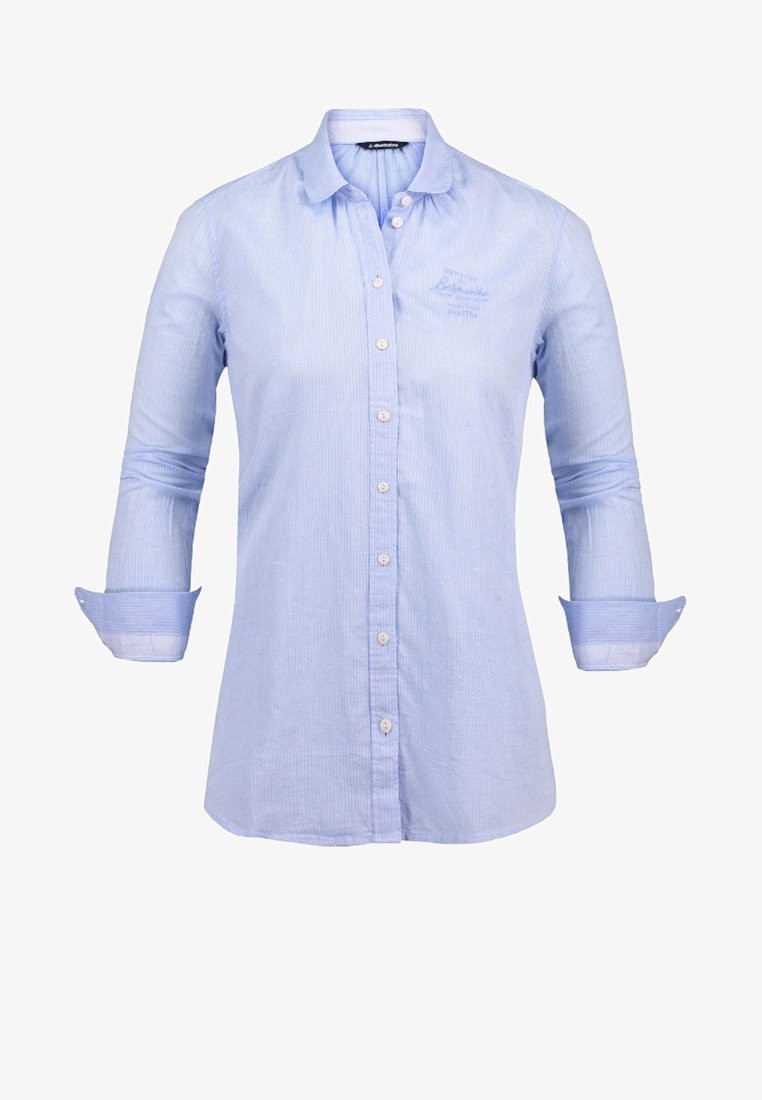 Chemise bleu clair à manches longues avec col, boutons blancs, poignets retournés, avec une broderie discrète sur le côté gauche de la poitrine.
