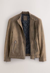 Bruine leren jas met doorgestikte zwarte binnenvoering, rits aan de voorkant en ritszakken, plat liggend tegen een beige achtergrond.