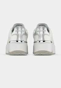 Άσπρα δερμάτινα sneakers με πλατφόρμα που διαθέτουν μεταλλική ασημί λεπτομέρεια στη φτέρνα και χρωμιωμένο διακοσμητικό στοιχείο στη σόλα. Ομαλή υφή συνολικά.