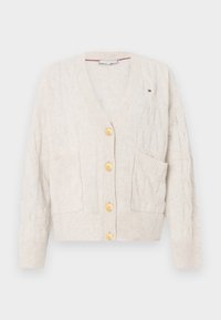 Cardigan lavorato a maglia color crema con scollo a V, quattro bottoni dorati, motivo a trecce e due tasche frontali. Presenta polsini e orlo a costine.