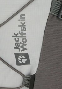 Grijs en witte Jack Wolfskin-stof met een pootlogo, gestructureerd oppervlak en een donkergrijze accentstrap en sluiting.